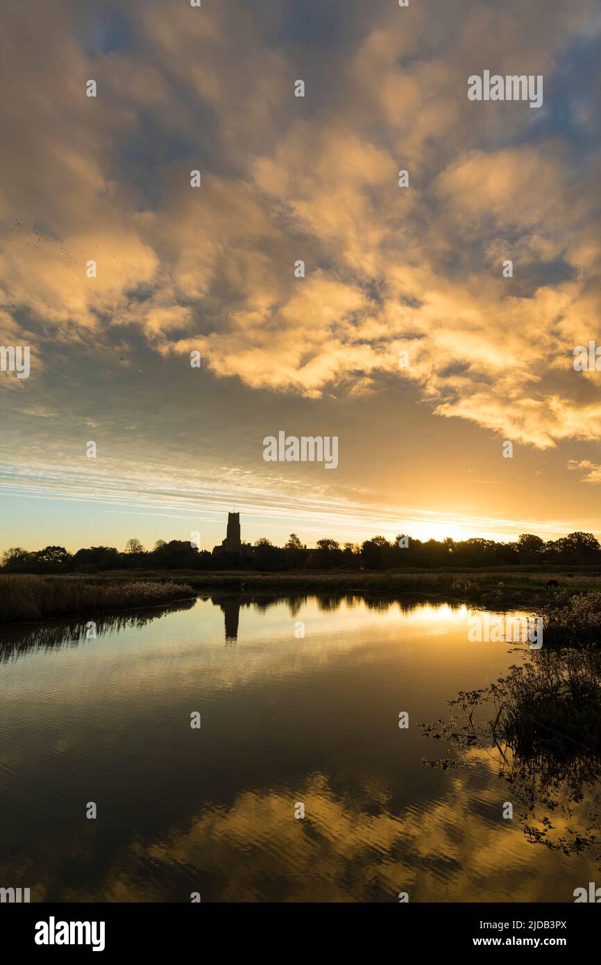 Blick über die Sümpfe bei Sonnenaufgang zur Blythburgh Church; Suffolk, England Stockfoto