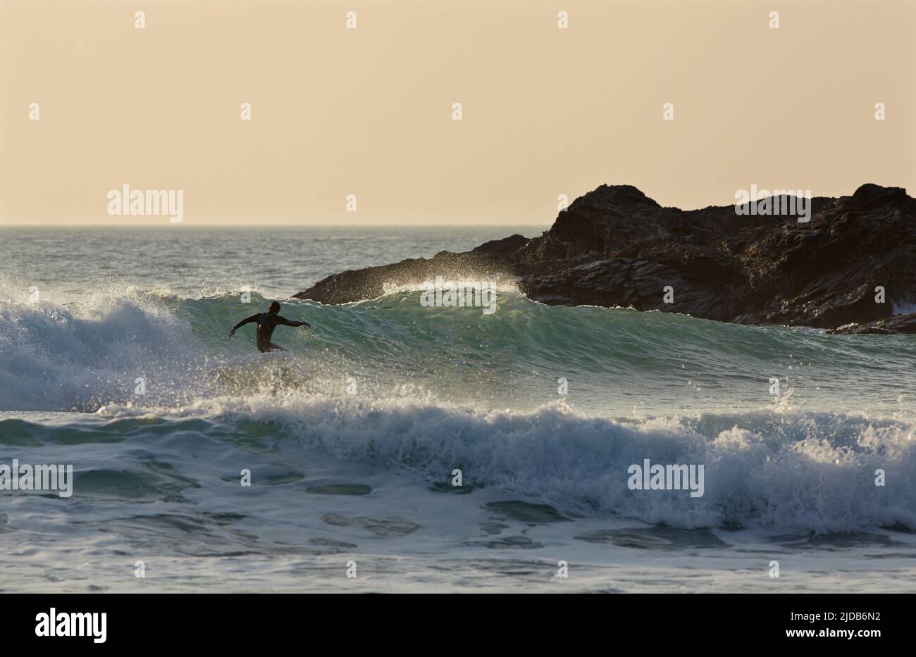 Surfen in Constantine Bay bei Sonnenuntergang, nahe Padstow, Cornwall, Großbritannien; Cornwall, England Stockfoto