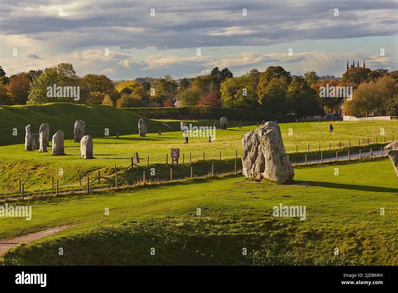 Touristen auf dem Rasen bei prähistorischen Standing Stones in Avebury, Wiltshire, Großbritannien; Avebury, Wiltshire, England Stockfoto
