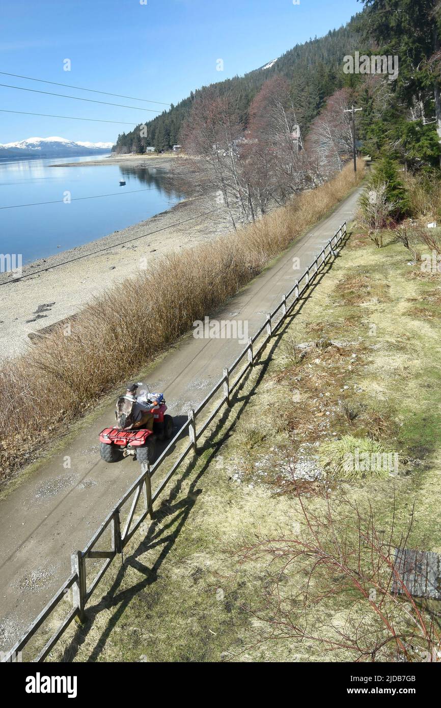 Ein Geländefahrzeug fährt die Mehrzweckstraße in Tenakee Springs, Alaska, hinunter. Normale Kraftfahrzeuge sind im kleinen Südosten des Bösen nicht erlaubt... Stockfoto