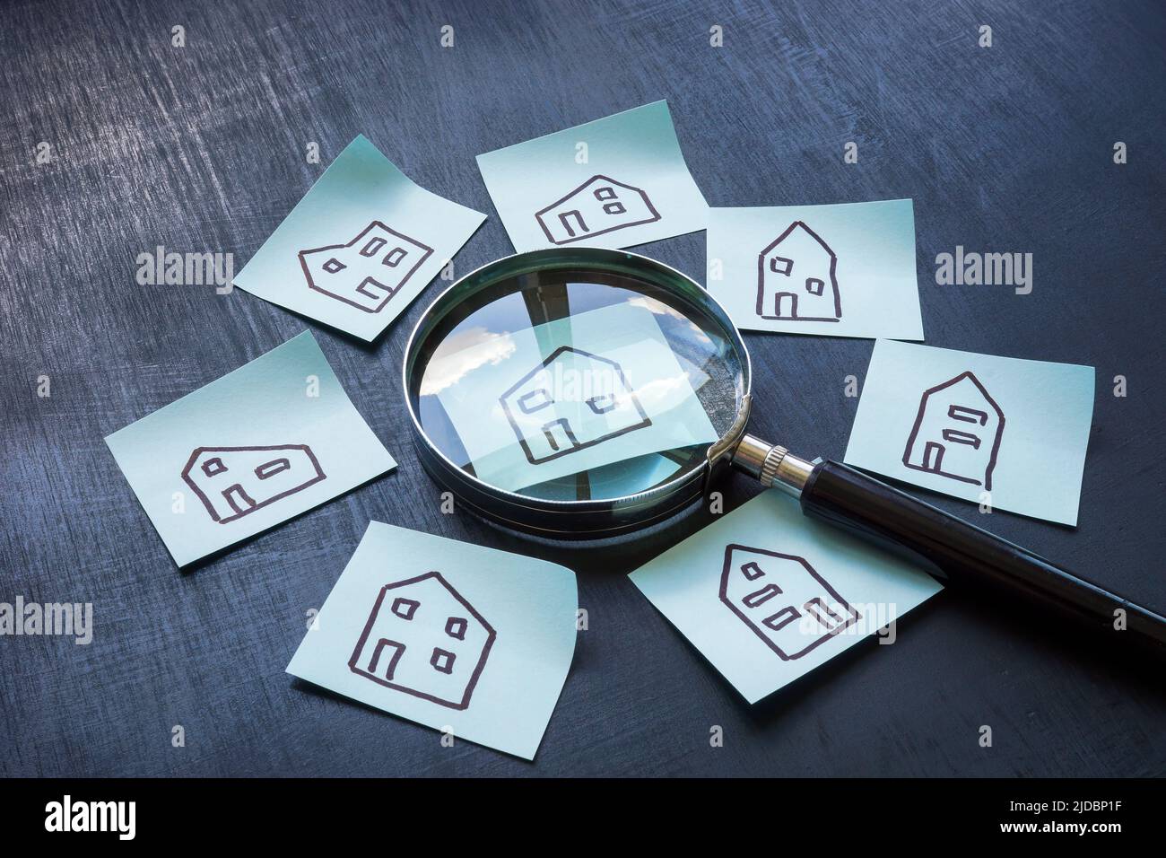Immobilienhaus Bewertung Konzept. Zeichnungen von Häusern auf Aufklebern und einer Lupe. Stockfoto