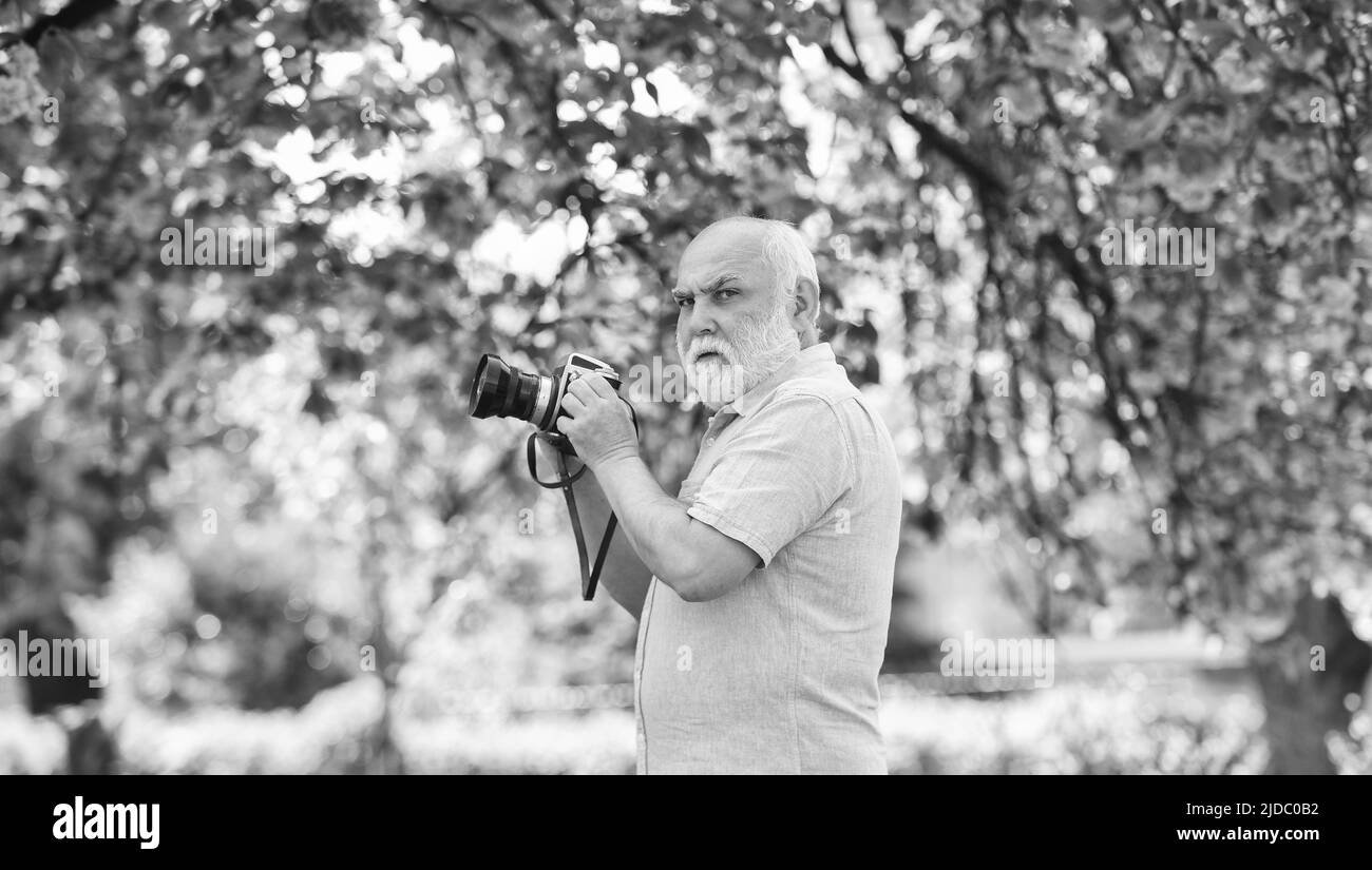 Fotograf Mann nehmen Sakura fröhliche Blüte Foto. Kirschblütengarten. Fotograf fotografiert berühmte Kirschblüten. Frühling Saison mit Stockfoto