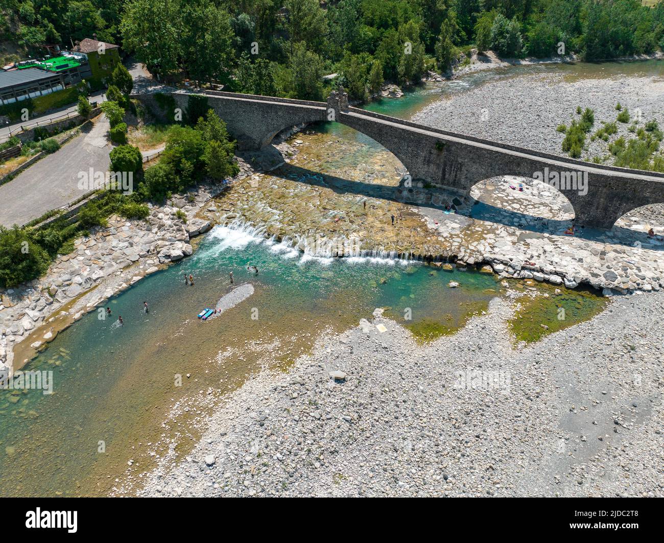 Luftaufnahme. Trockenheit und trockene Flüsse. Römische Brücke von Bobbio über den Fluss Trebbia, Piacenza, Emilia-Romagna. Italien. 06-16-2022. Flussbett mit Steinen Stockfoto