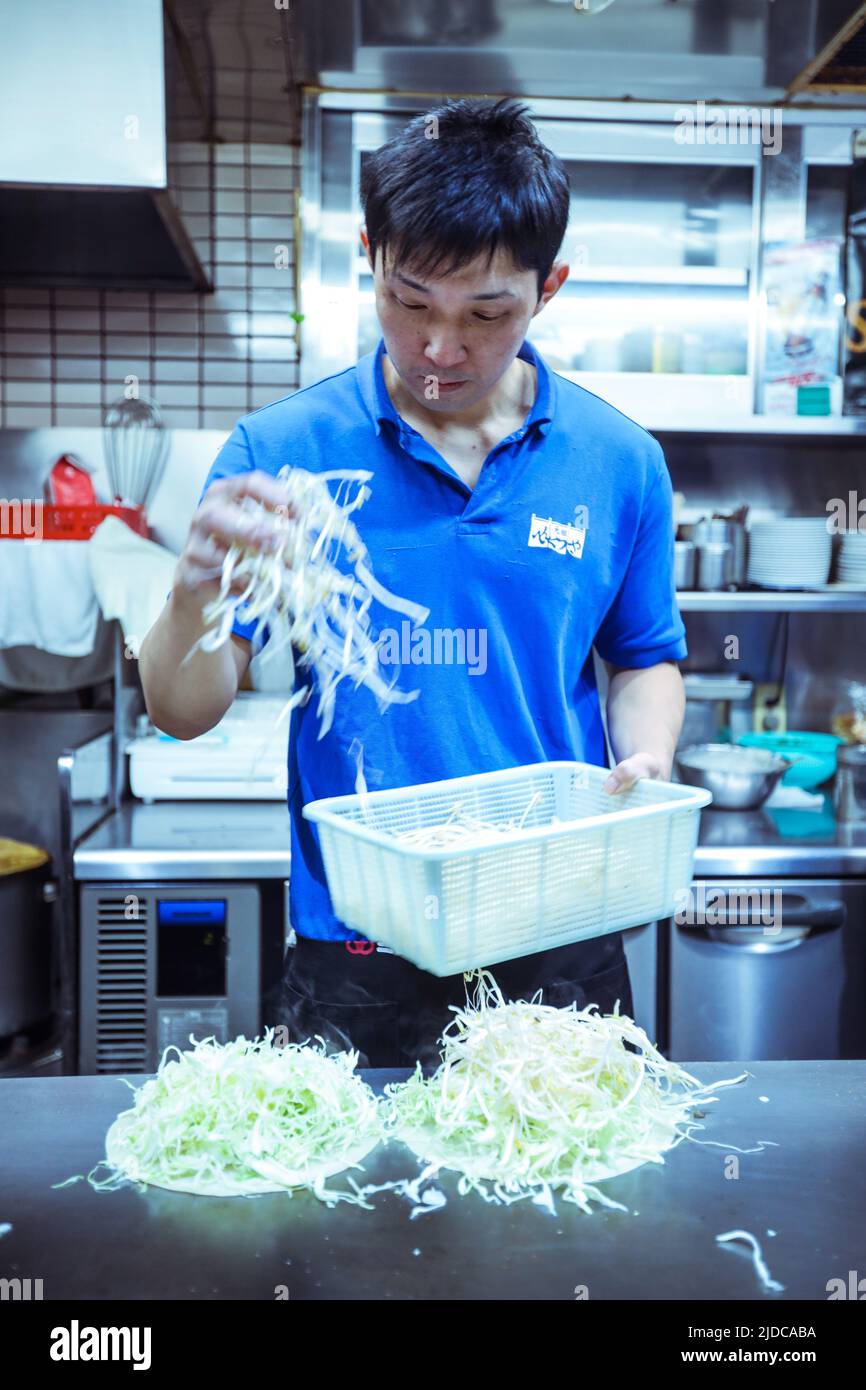 Lokaler Koch bereitet das typische japanische Gericht Okonomiyaki im Hiroshima Restaurant, Japan, zu Stockfoto