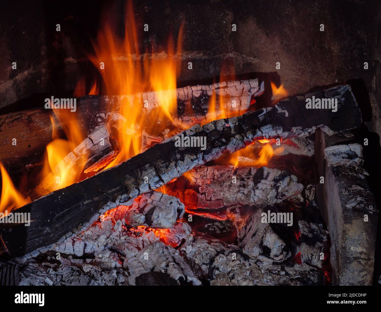 Flamme der schwelenden und brennenden Kohle im Kamin Stockfoto