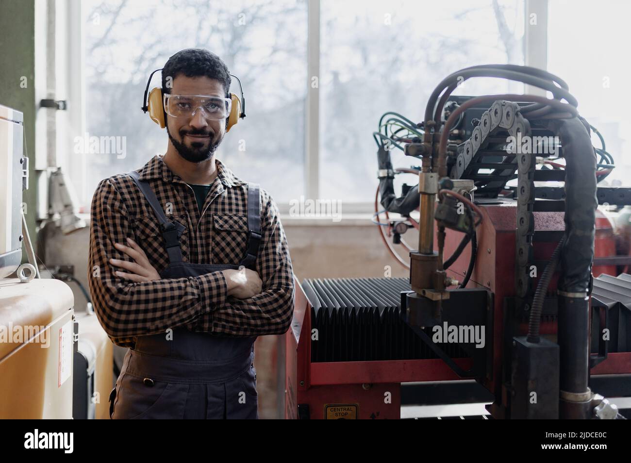 Porträt eines Arbeiters in der Schwerindustrie mit Sicherheitskopfhörern und in der Industriefabrik Stockfoto