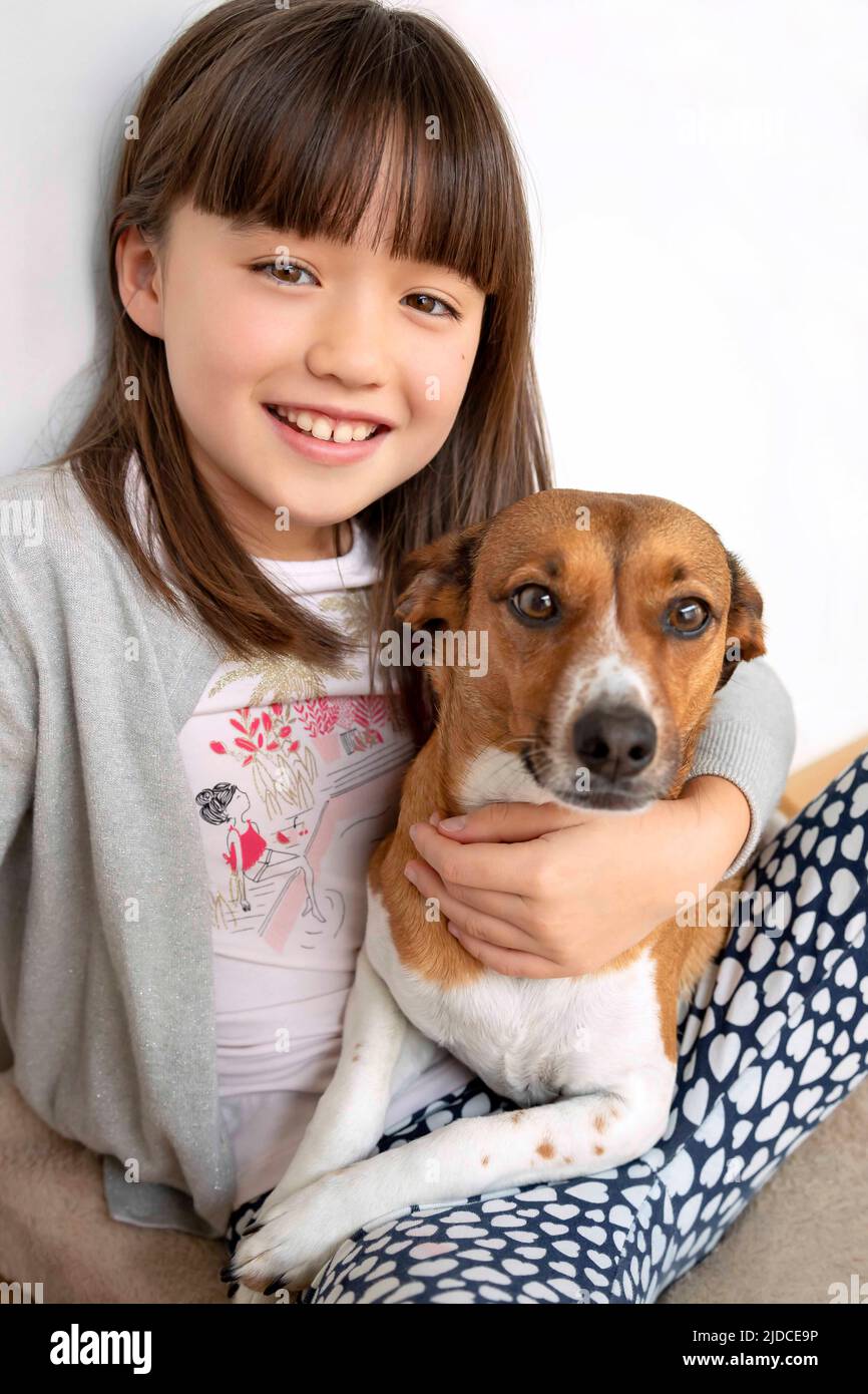 Acht Jahre altes Mädchen umarmt ihren Hund Stockfoto