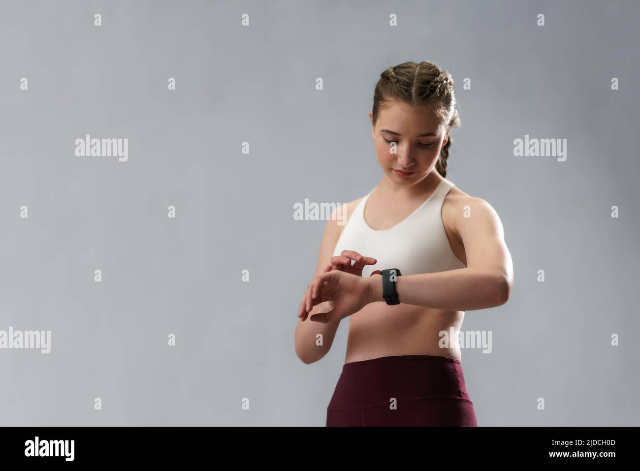 Aufnahme einer jungen Frau, die die Sportsmartwatch ansieht. Fitness-Frau überprüft ihre Leistung. Stockfoto