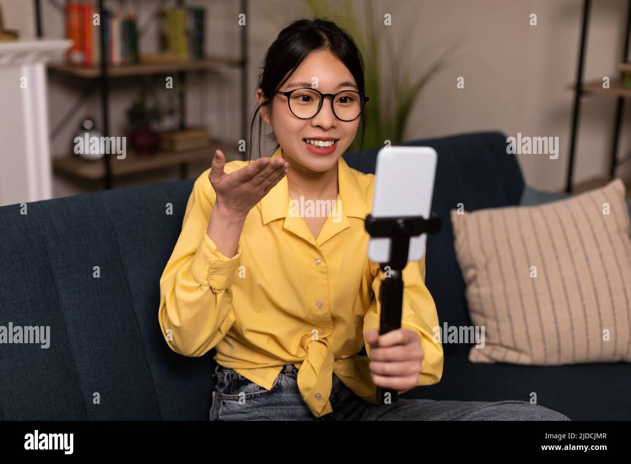 Asiatische Blogger Dame Macht Video Auf Handy Sitzen Zu Hause Stockfoto