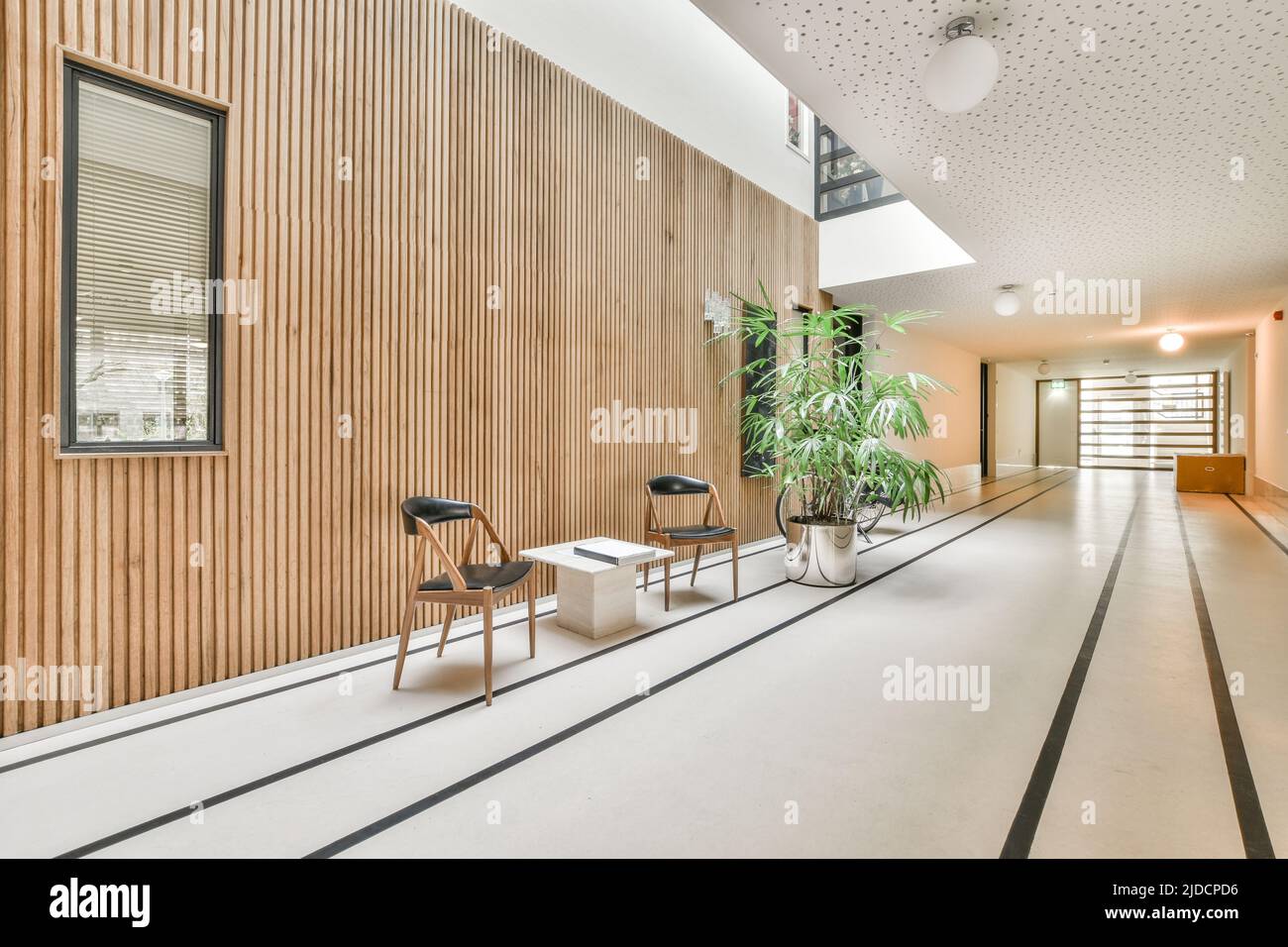 Ein kompakter, heller Korridor mit Holzwänden und Fliesenboden Stockfoto