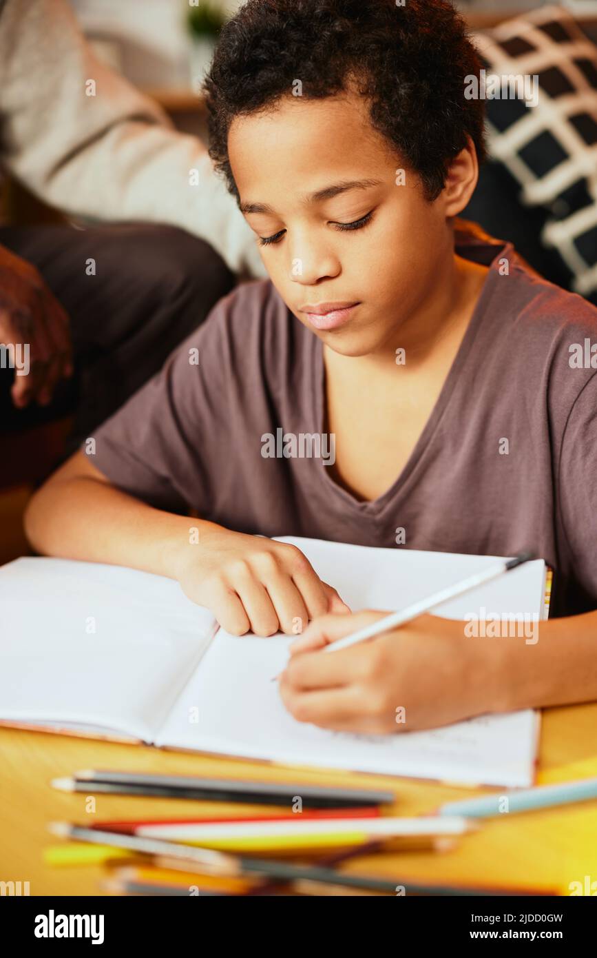 Intelligenter afrikanischer Junge, der seine mathematischen Hausaufgaben mit ein wenig Hilfe seines Opa macht. Nachhilfe und Bildung Stockfoto