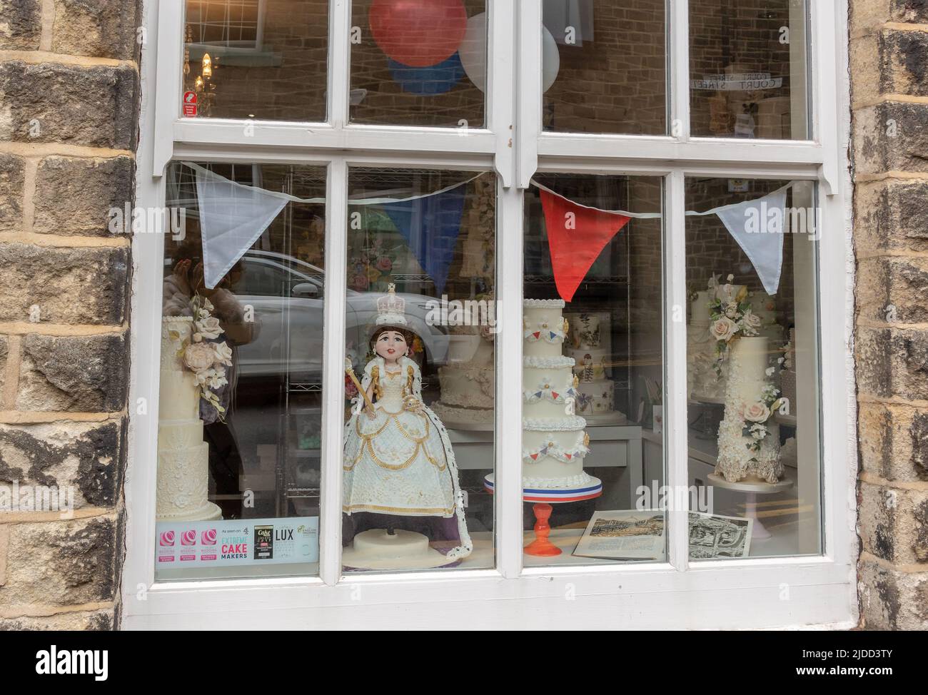 Village Cake Shop Witwe Display mit Queen Jubilee Kuchen Dekoration in Saddleworth, England. Stockfoto