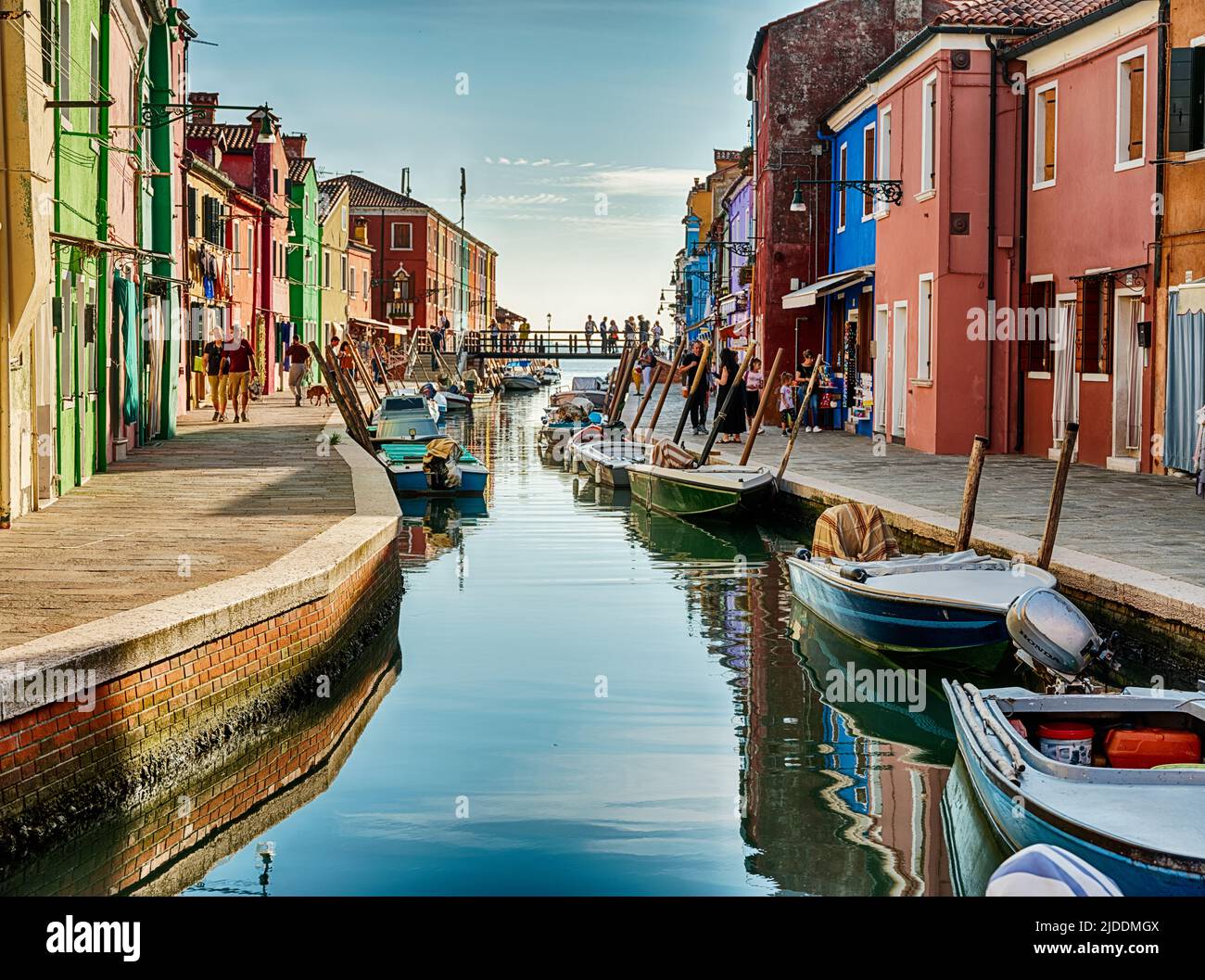 Boote fahren auf beiden Seiten eines schmalen Kanals in der kleinen Stadt Burano bei Venedig. Stockfoto