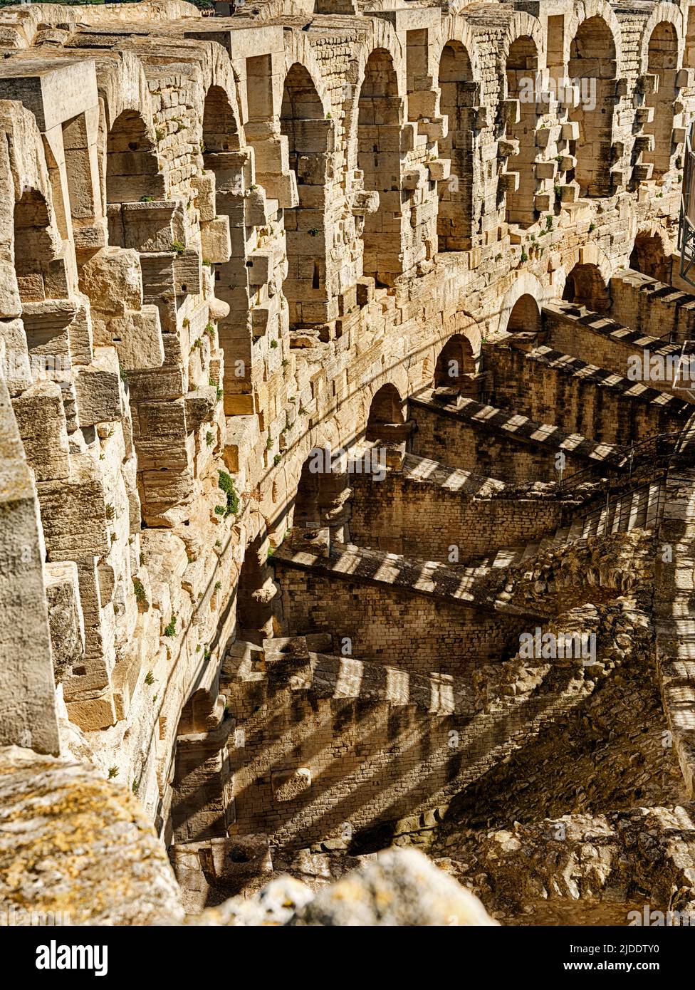 Schatten werden von den Sitzen an die Außenwände der anikanten römischen Arena in Arles geworfen. Stockfoto