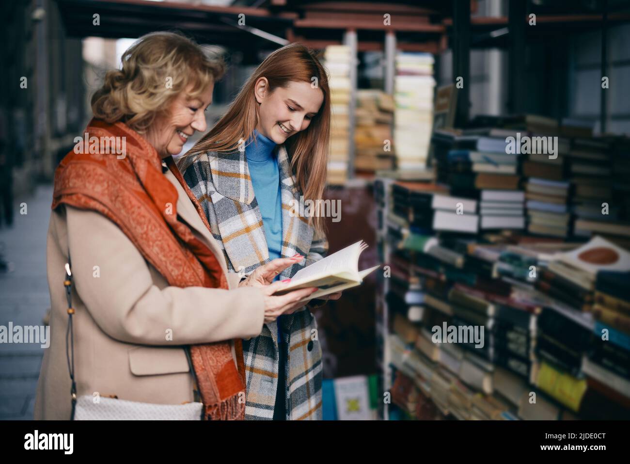 Eine Großmutter und eine Enkelin wählen Bücher im Buchladen aus. Stockfoto