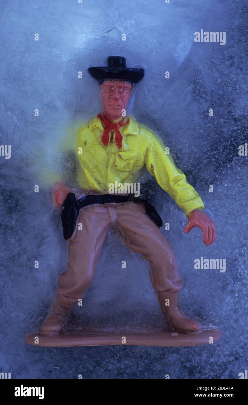 Plastikmodell von Cowboy im Eis Zeichnung seiner Waffe Stockfoto