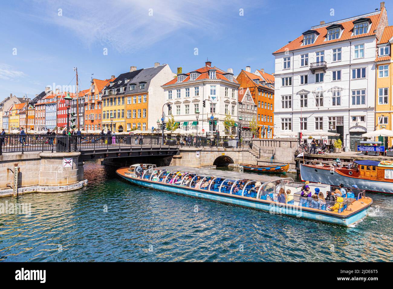 Ein Touristenboot, das Nyhavn, die farbenfrohe Kanalpromenade aus dem 17.. Jahrhundert in Kopenhagen, Dänemark, passiert. Stockfoto