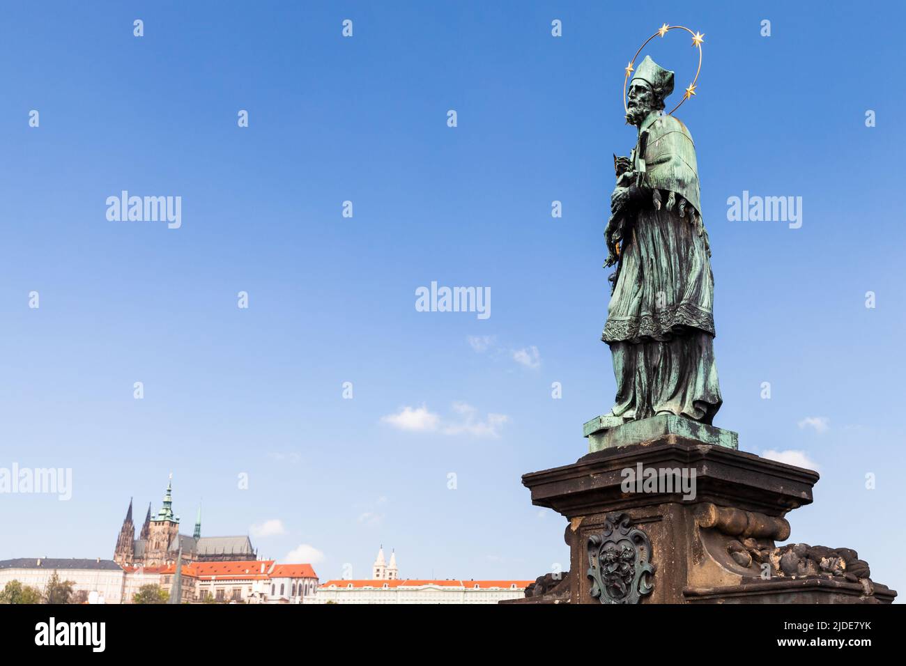 Die Statue des Schutzheiligen Nepomuk an der Karlsbrücke steht unter blauem Himmel. Wahrzeichen von Prag, Tschechische Republik Stockfoto Die Statue des Schutzheiligen Nepomuk an der Karlsbrücke steht unter blauem Himmel. Wahrzeichen von Prag, Tschechische Republik Stockfoto