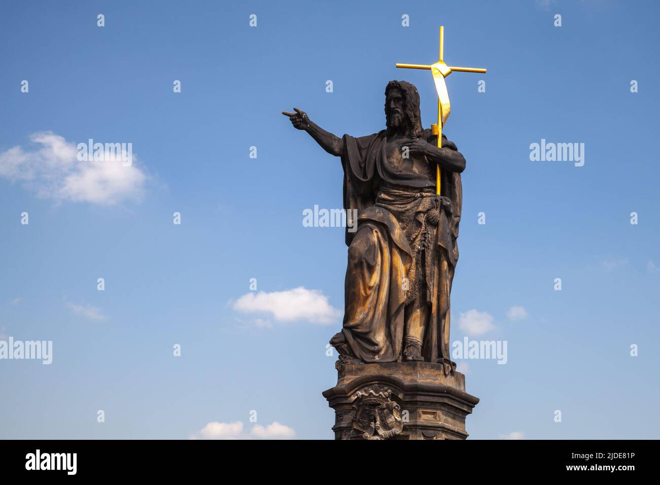 Die Statue des heiligen Johannes des Täufers an der Karlsbrücke steht tagsüber unter blauem Himmel. Prag, Tschechische Republik Stockfoto