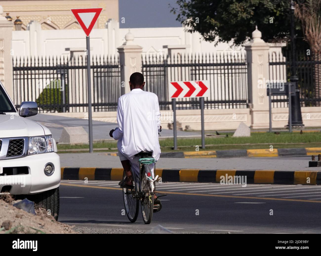 Sharjah, VAE 21. Februar 2020: Ein Mann in Nationaltracht fährt mit dem Fahrrad. Stockfoto