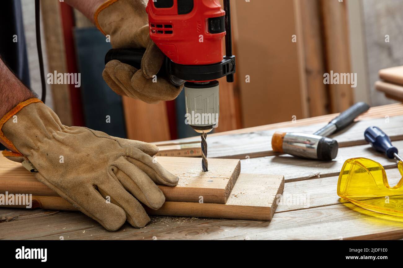 Bohren Sie Elektrowerkzeug, Handgelber Bohren Holz. Bauindustrie, Tischler Arbeitstisch Nahaufnahme Stockfoto