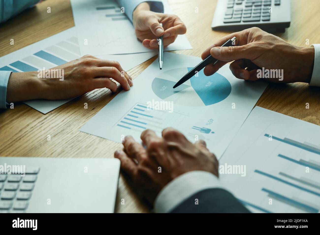 Geschäftsleute diskutieren die Geschäftsmarketingstrategie und analysieren die Berichtdiagramme am Schreibtisch Stockfoto