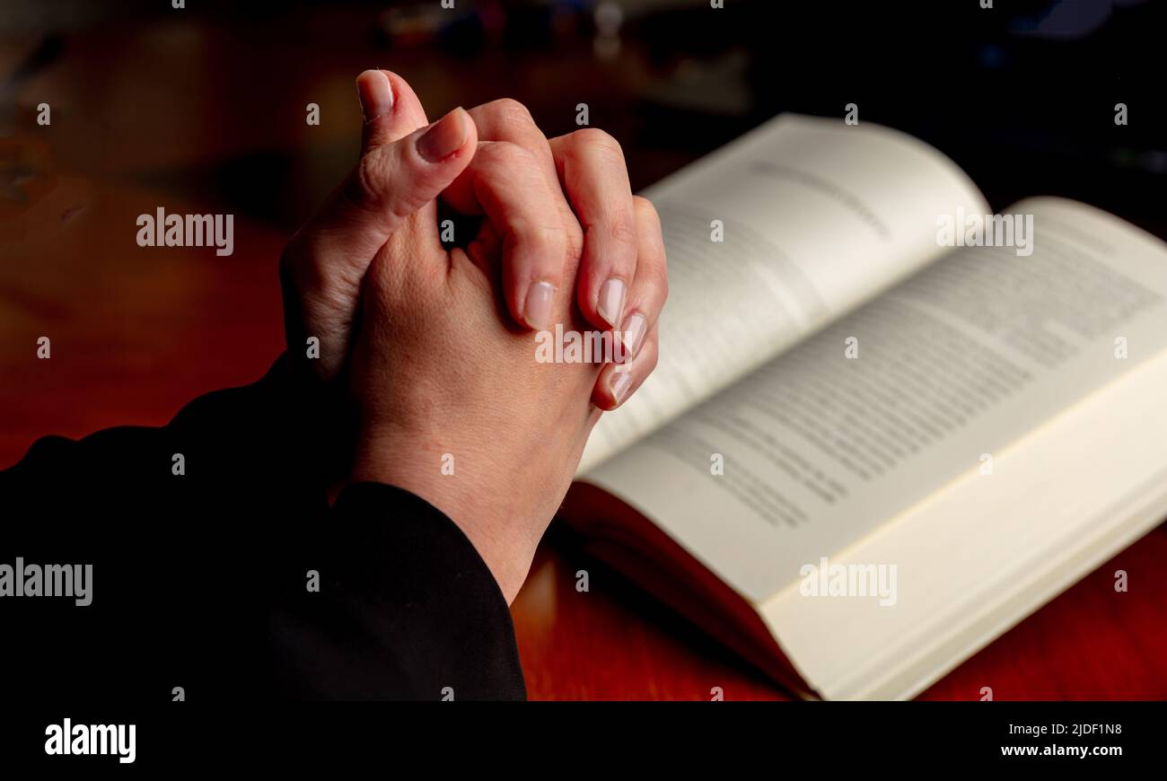 Gebet, Frau überreicht ein offenes Buch der Heiligen Bibel, Holzschreibtisch Hintergrund. Beten Sie zu Gott, Glauben, Religion und Spiritualität Konzept Stockfoto