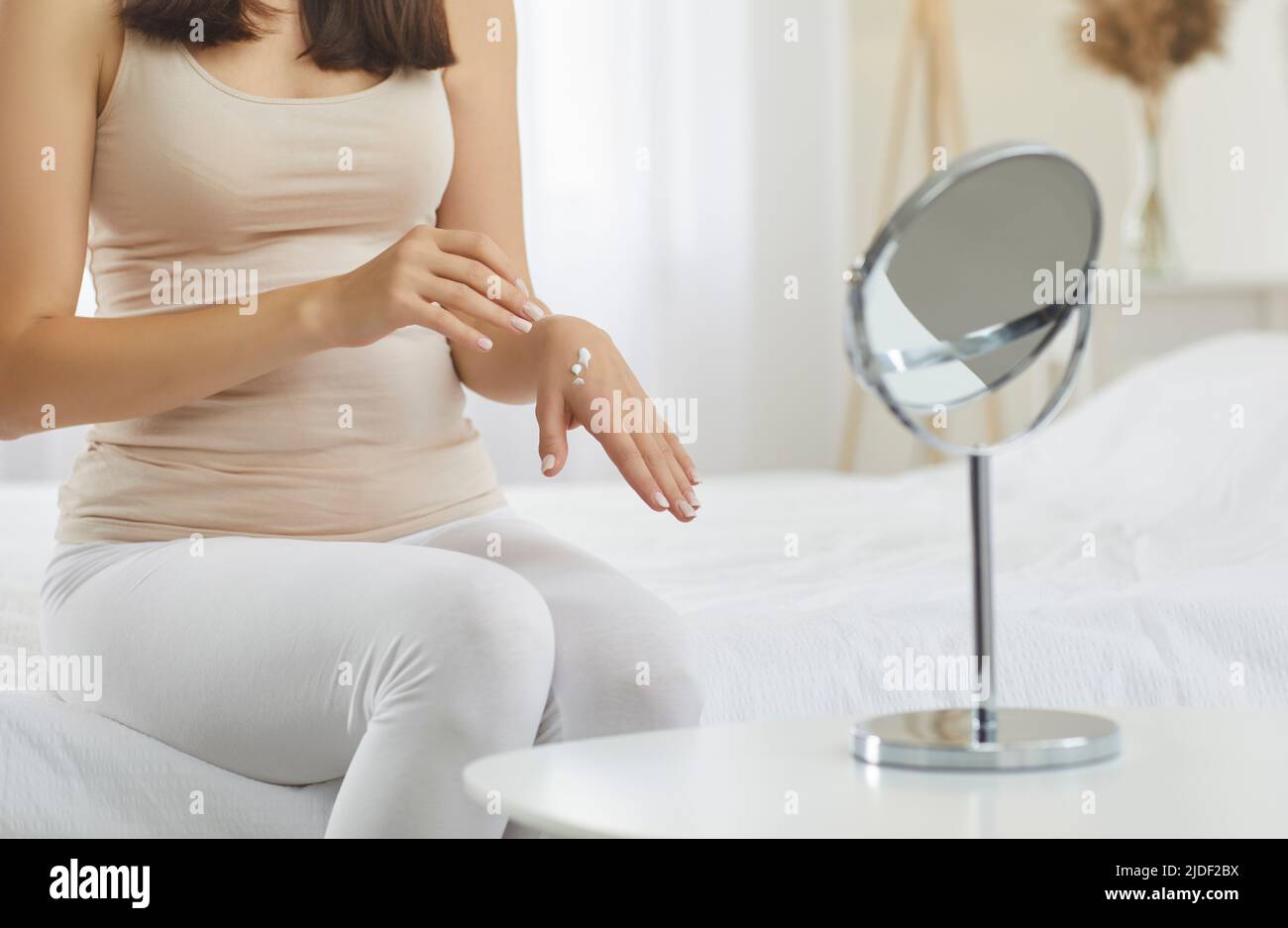 Frau am Morgen verwendet kosmetische Feuchtigkeitscreme, die die ihrer Hände den ganzen Tag schützen wird. Stockfoto