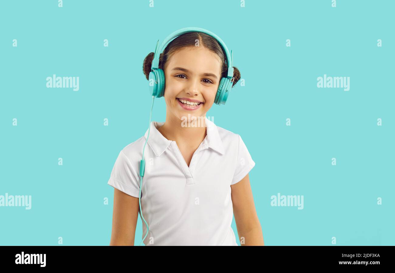 Lächelndes Teenager-Mädchen Kind hören Musik in den Kopfhörern Stockfoto