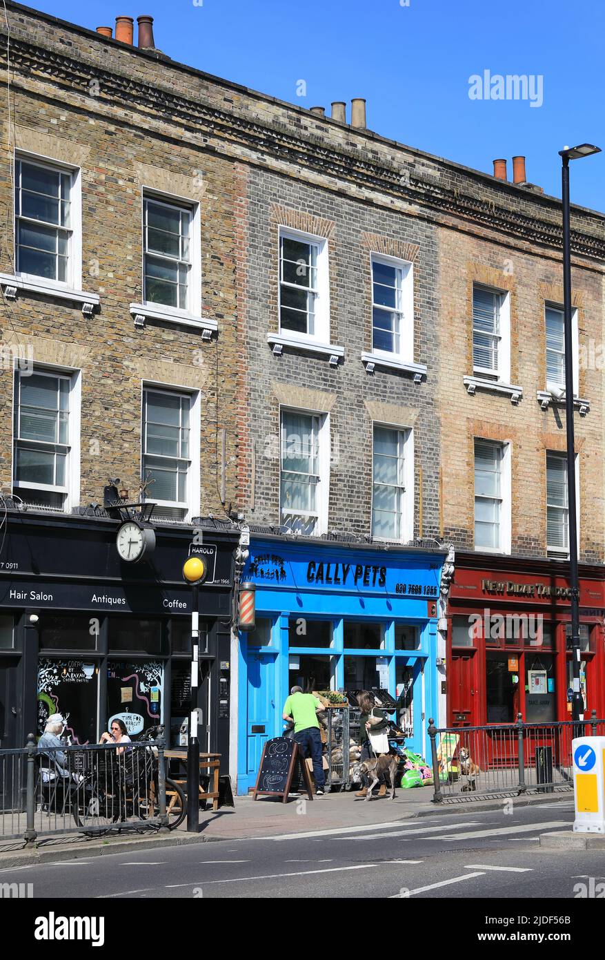 Farbenfrohe Geschäfte und Cafés an der Caledonian Road in der Nähe der Caledonian Road und des Bahnhofs Barnsbury Overground in Islington, im Norden von London, Großbritannien Stockfoto