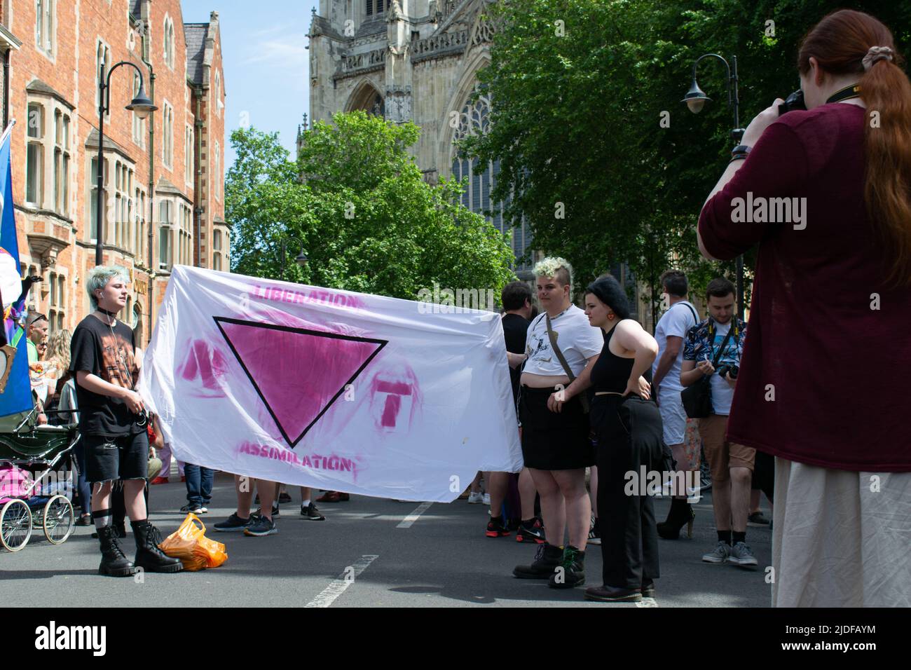 York Pride Parade. Banner mit Text Befreiung Assimilation und invertierte rosa Dreieck bilden Wort nicht Stockfoto