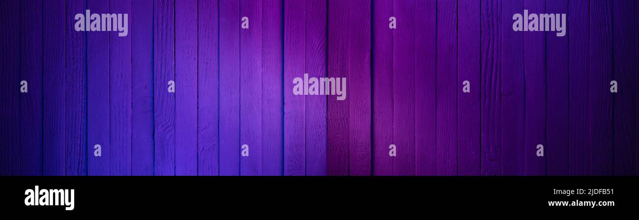 Holzwand in Cyan und Magenta Farben lackiert. Dunkle Oberfläche mit Neonfarben Stockfoto