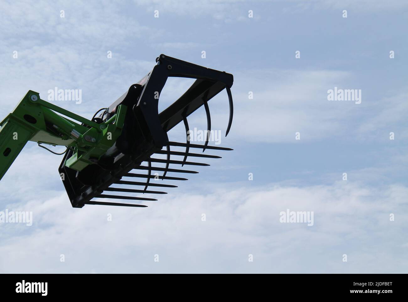 Ein landwirtschaftliches Gras greifen auf einem langen Hydraulikarm. Stockfoto