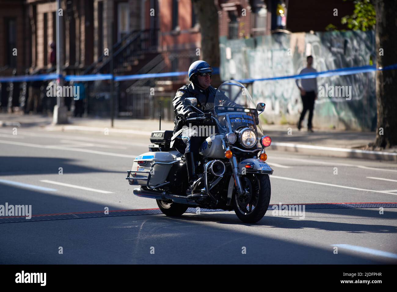 Brooklyn, New York, USA - November 3. 2019: Polizeibeamter, der während des NYC-Marathons auf einem Motorrad unterwegs ist und Straße und Verkehr bewacht Stockfoto