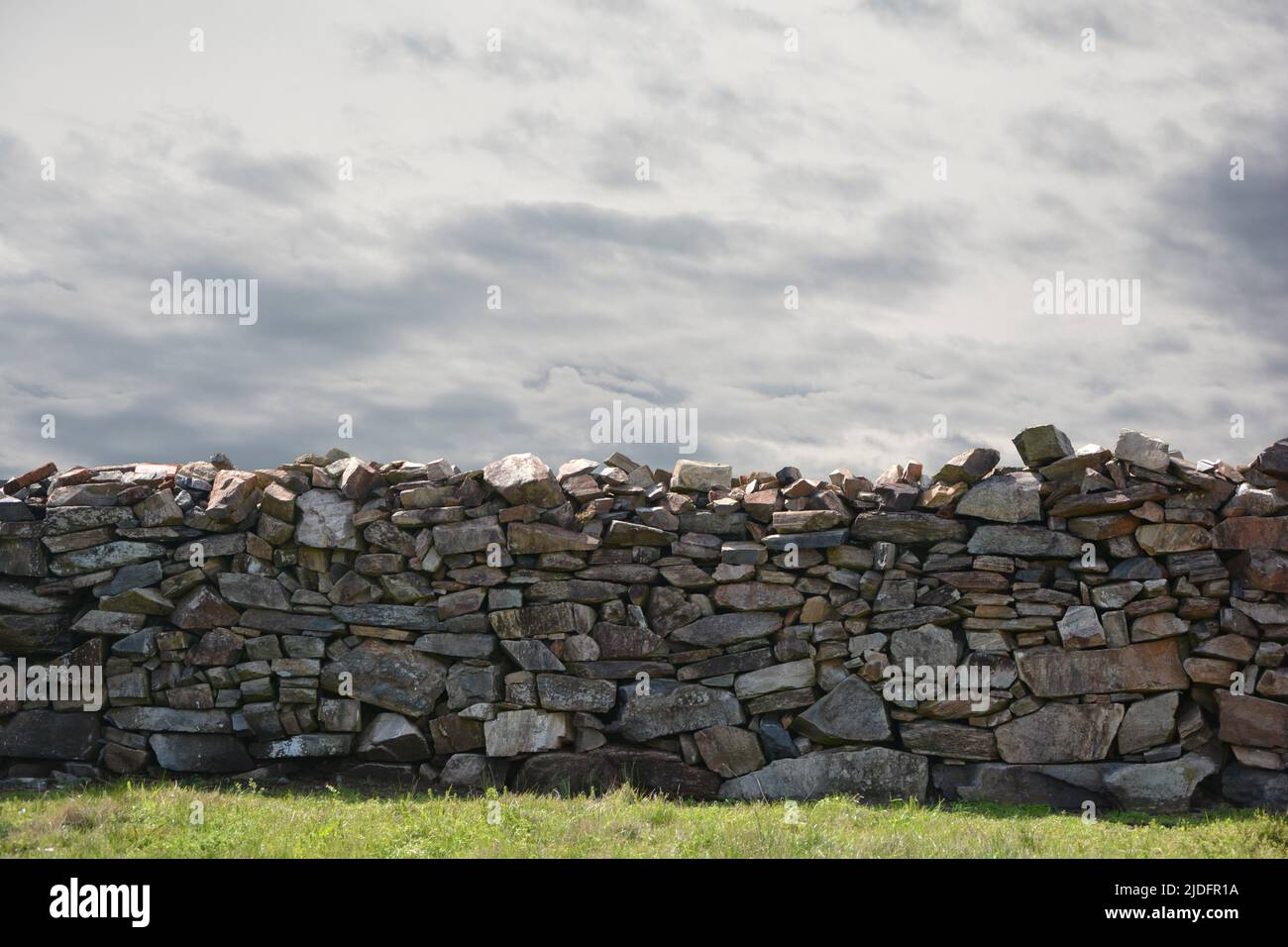 muro de piedra con cielo nublado gris Stockfoto
