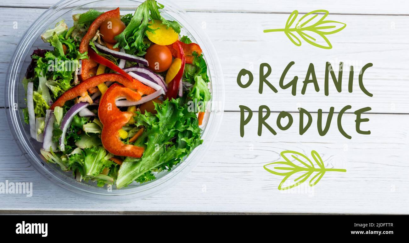 Bild von Bio-Produkten Text in grün über Schüssel mit frischem Salat auf weißen Brettern Stockfoto