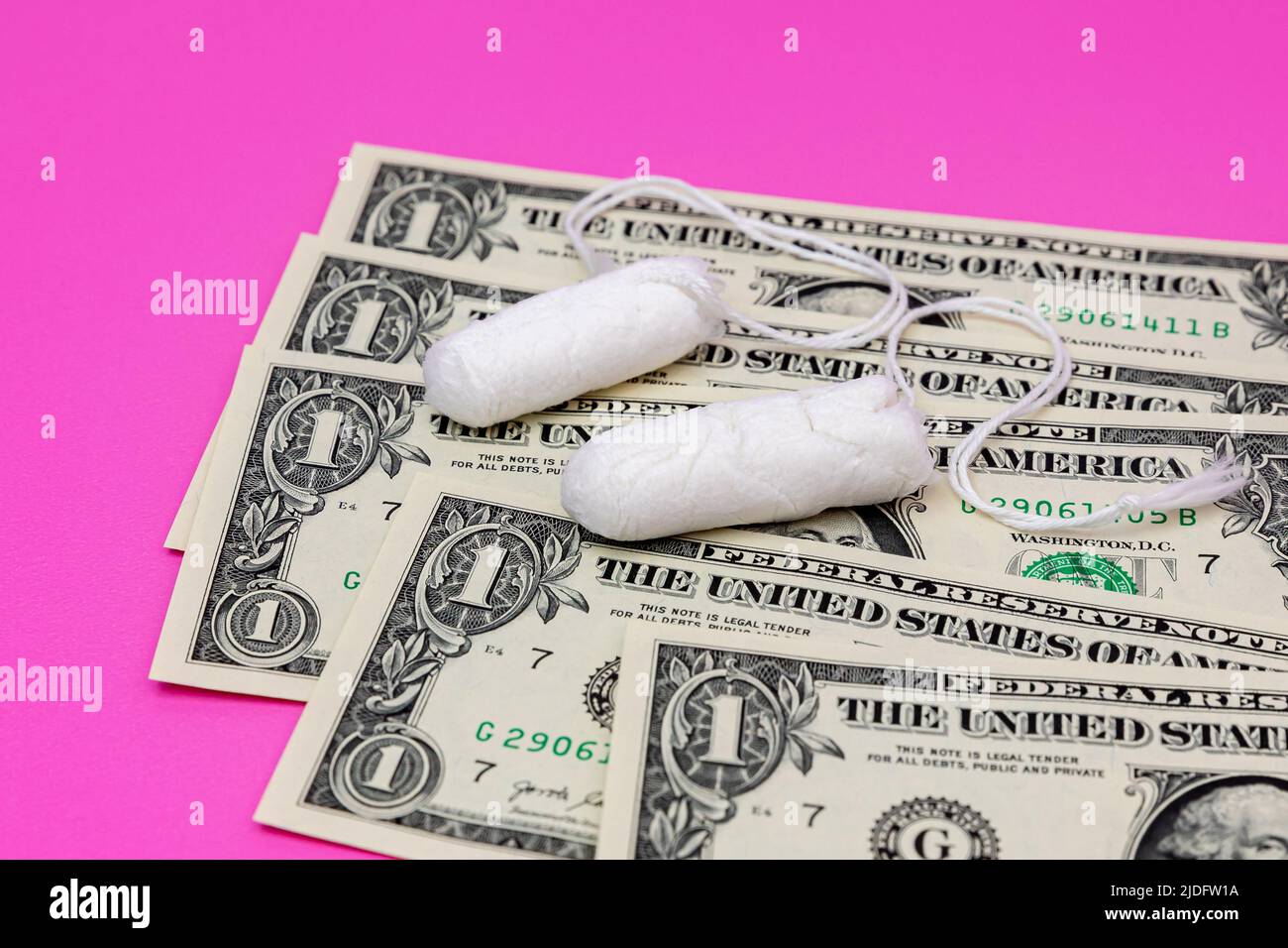 Tampons und Bargeld. Tamponmangel, Steuern, rosa Steuern und feminine Hygieneprodukte Preissteigerung Konzept Stockfoto