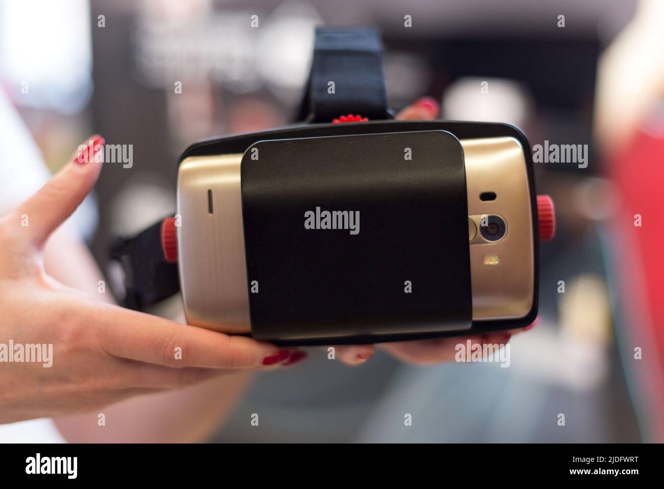 Das Weibchen hält eine VR-Brille mit einem Smartphone. Probefahrt Option zum Ausprobieren der VR-Technologie. Stockfoto