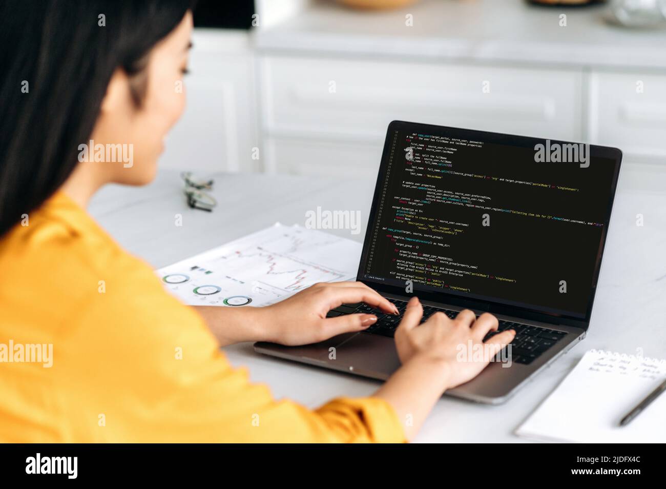 Über die Schulter blicken Sie auf einen Laptop mit Programmiercode auf dem Bildschirm, einer asiatischen Frau, die IT-Spezialistin. Intelligente professionelle Programmiererin, die mit einer Software und Codierungstechnologie arbeitet und Codes schreibt Stockfoto
