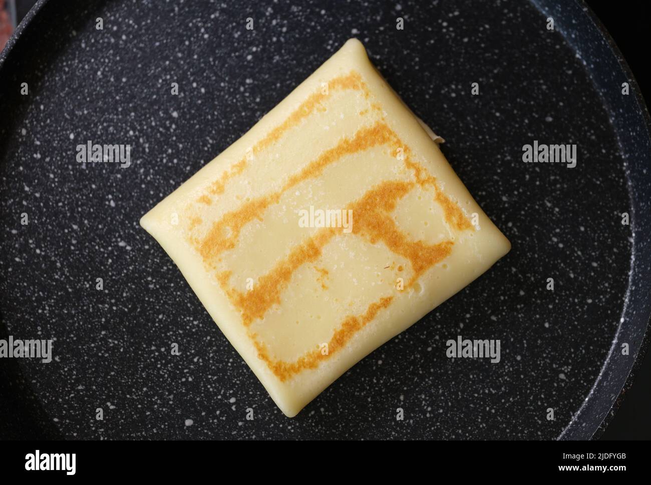 Mehlpfannkuchen mit Füllung in der Pfanne Stockfoto