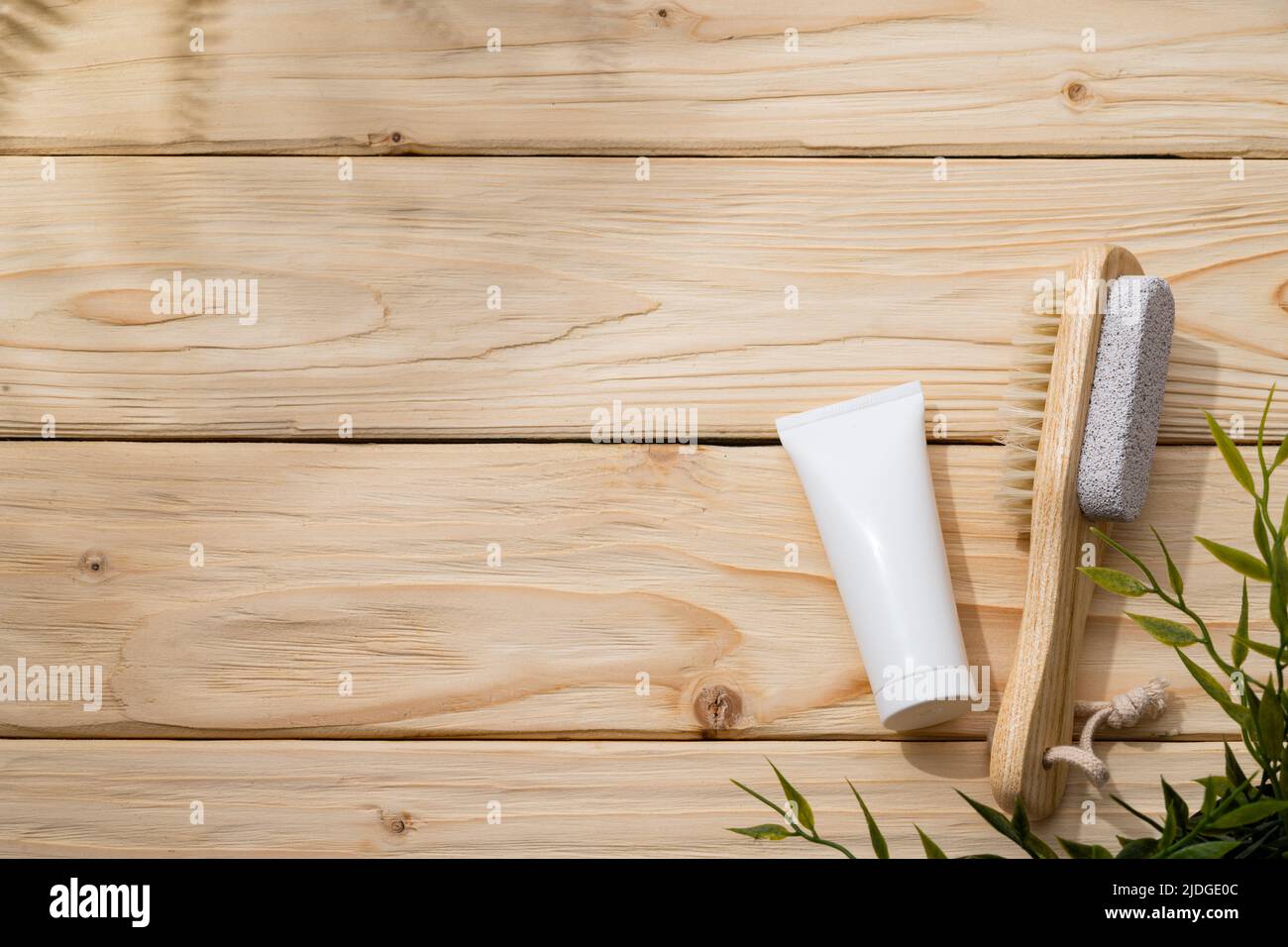 Fußbürste und Fußcreme auf Holzgrund Stockfoto