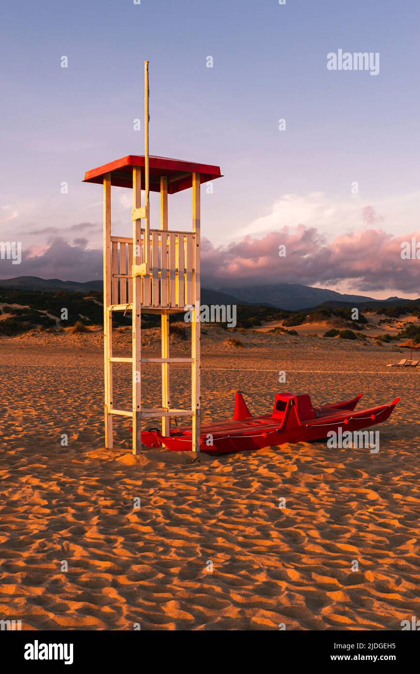 Salvataggio Rettungsschwimmer Wachturm und Rettungsboot am Sandstrand von Piscinas im goldenen Licht bei Sonnenuntergang, Costa Verde, Sardinien, Italien Stockfoto