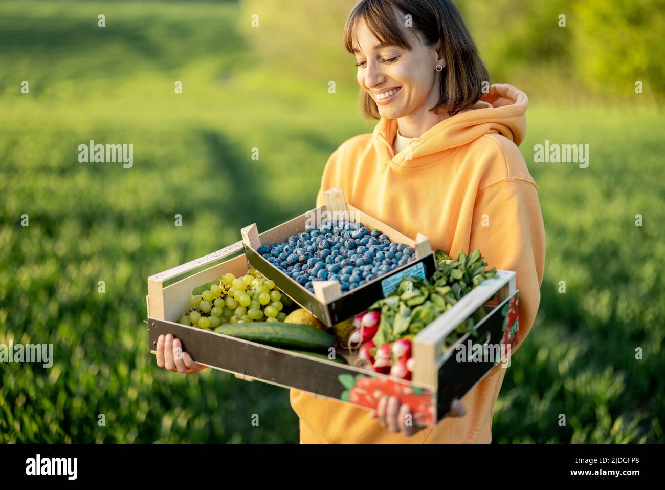 Frau mit frischem Essen auf Ackerland Stockfoto