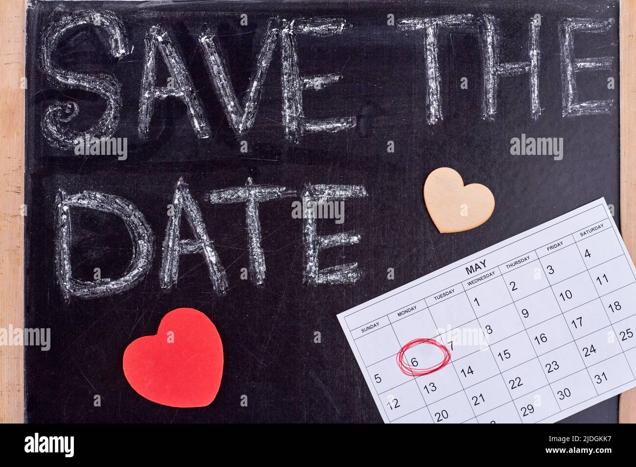 Speichern Sie das Datumskonzept mit Papierherzen. Kalender mit eingekreisten Datum. Stockfoto