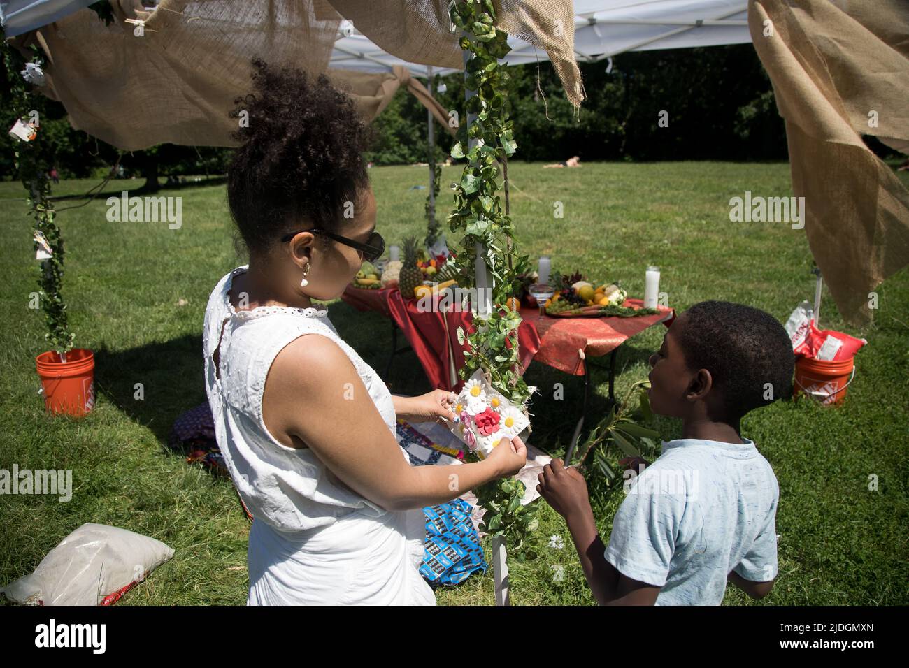 NEW YORK, 21. Juni 2022 (Xinhua) -- Chayanne Marcano, Kuratorin des Quilt-Projekts, hängt einen Patch für einen Quilt, der die Opfer der COVID-19-Pandemie während des jährlichen Juneteenth-Festivals 13. im Prospect Park im Stadtteil Brooklyn in New York, USA, am 19. Juni 2022 in Erinnerung rufen soll. Die Teilnehmer machten Kunstwerke oder schrieben Worte auf die Quilts, um an die an dem Coronavirus verstorbenen Familienmitglieder zu erinnern. Als sich die Afroamerikaner in New York anderen aus dem ganzen Land anschlossen, um an das Ende der Sklaverei in den Vereinigten Staaten zu erinnern, würdigten sie auch die dem C verlorenen Leben Stockfoto
