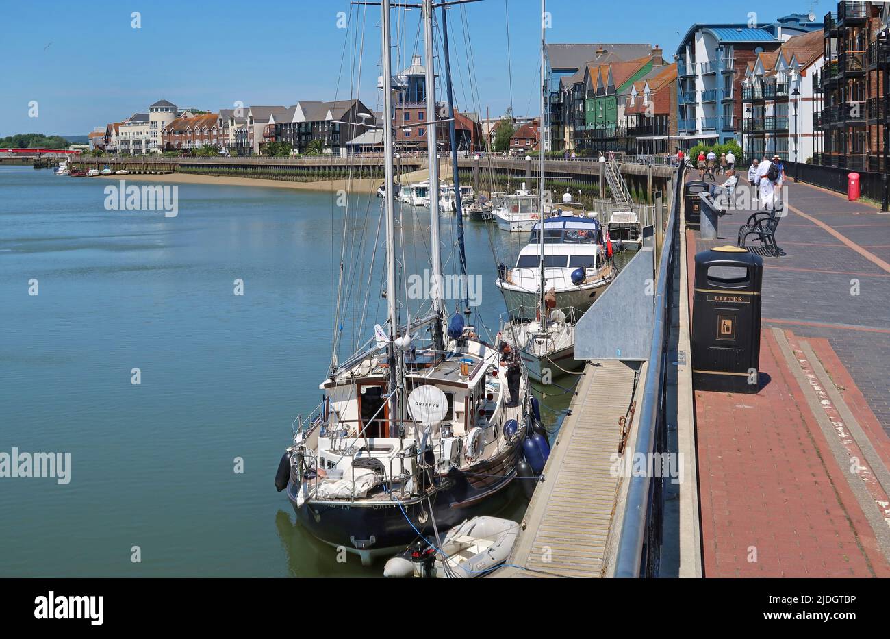 Littlehampton, West Sussex, Großbritannien. Die Yachten liegen am Ostufer des Flusses Arun. Zeigt den Fußweg am Fluss und das Stadtzentrum dahinter. Stockfoto