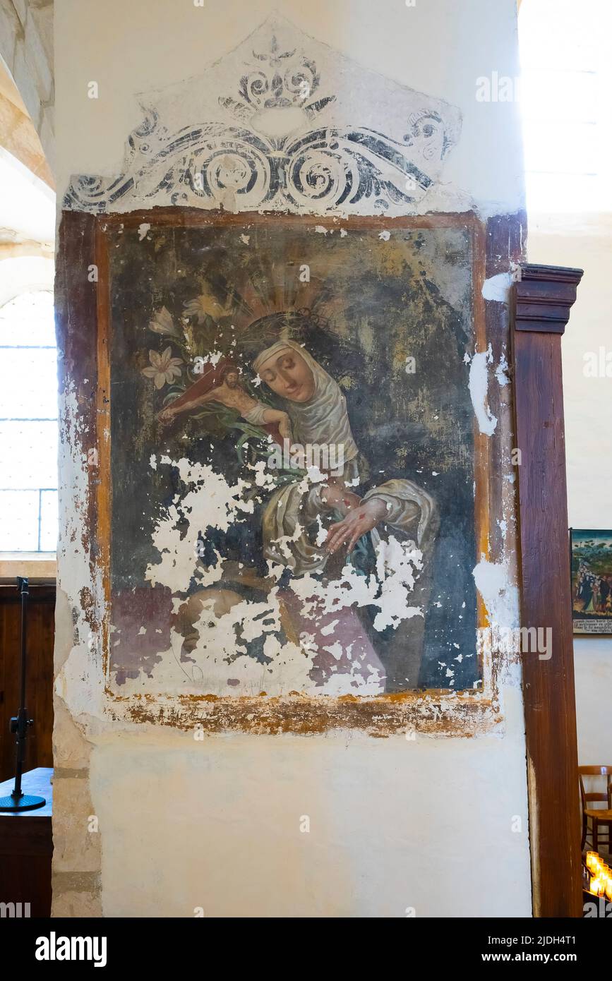 Die Reste des Freskens zeigen eine Figur in der Gewohnheit einer Nonne, die ein Kruzifix trägt und Stigmata auf ihren Händen zeigt. Im Inneren der Kirche von Saint Vorles Stockfoto