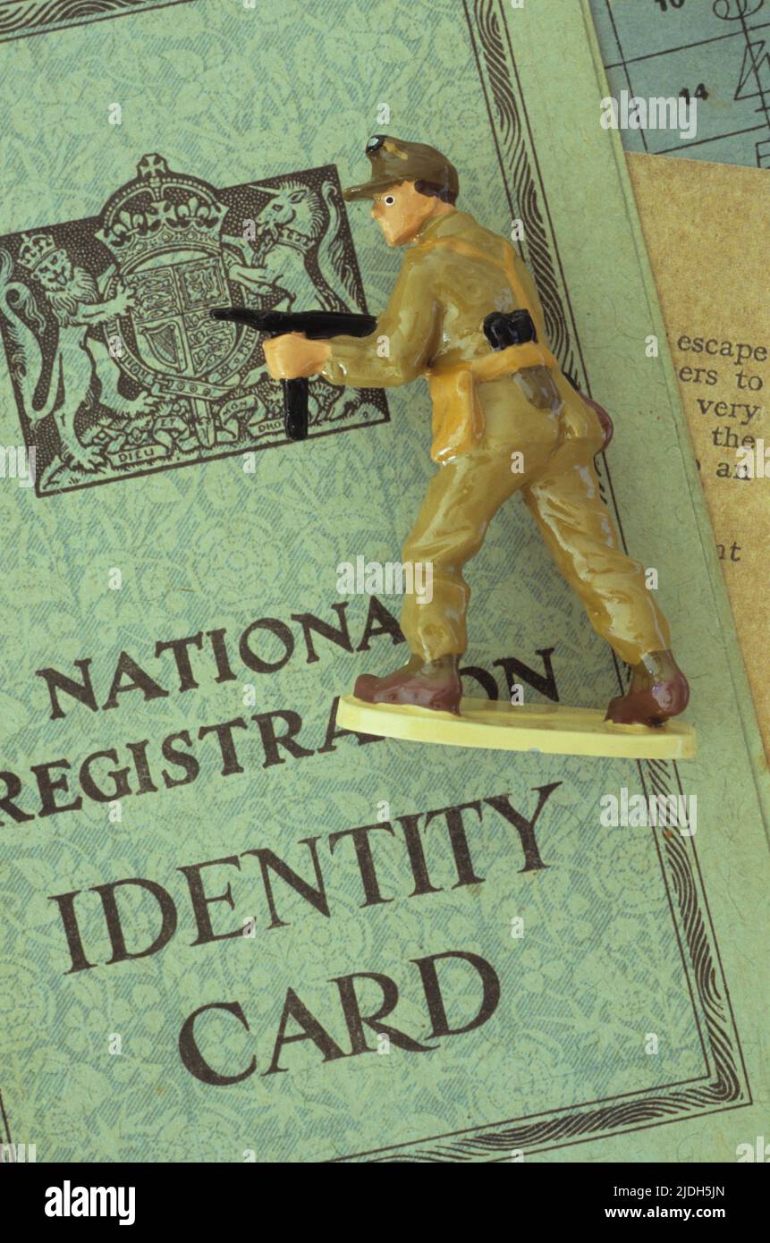 Leitmodell des Soldaten der alliierten Streitkräfte in Wüstenkleidung, das auf ein halbautomatisches Gewehr zielt und auf der britischen Identitätskarte des Weltkriegs 2 liegt Stockfoto