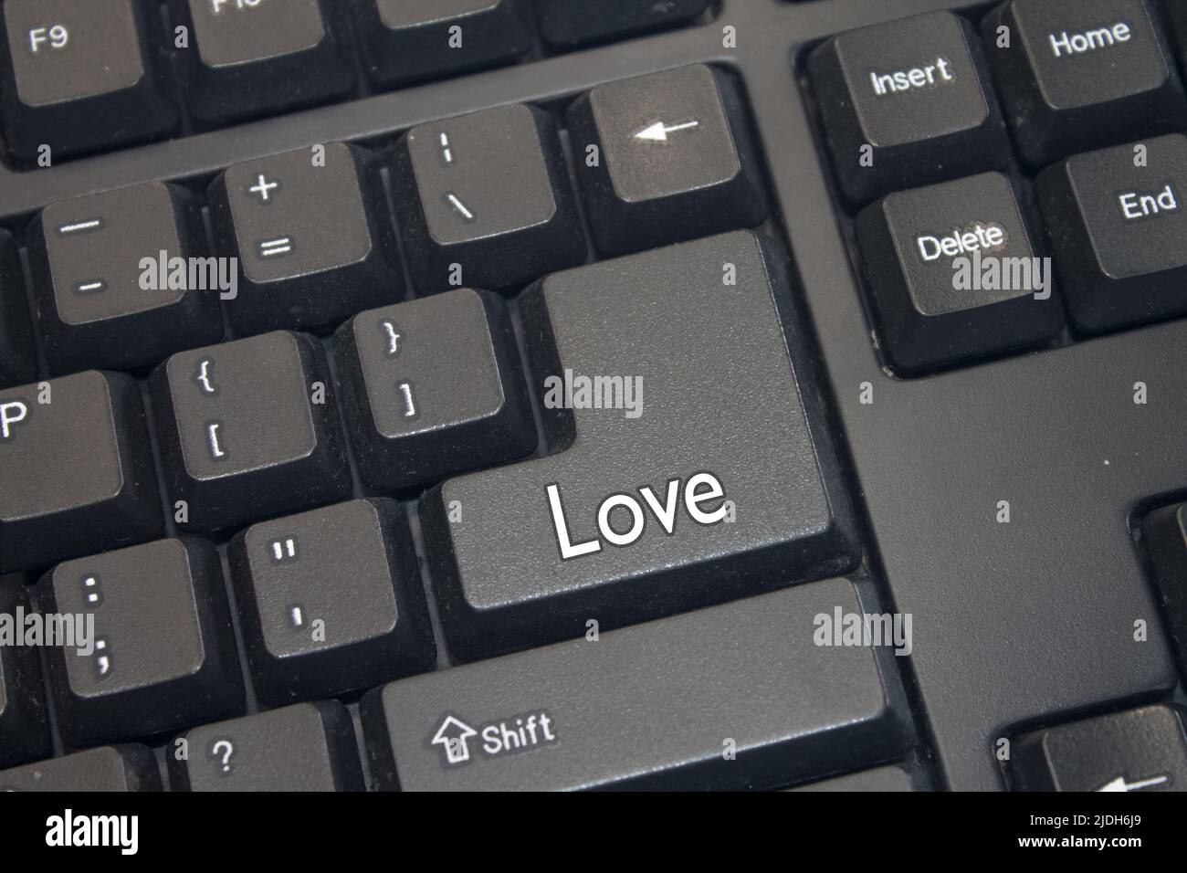 Schwarze Computertastatur mit Liebes-Text. Nahaufnahme eines elektronischen Computergeräteteils, einer Tastatur. Stockfoto