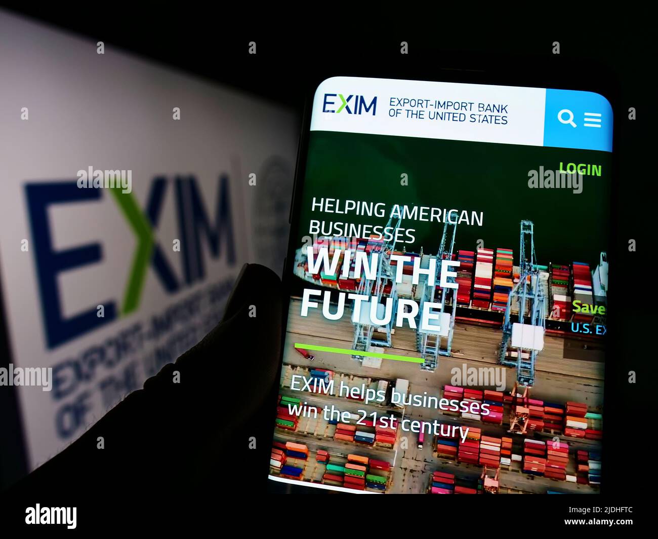 Person mit Smartphone und Website der Export-Import Bank of the United States (Exim) auf dem Bildschirm mit Logo. Konzentrieren Sie sich auf die Mitte des Telefondisplays. Stockfoto